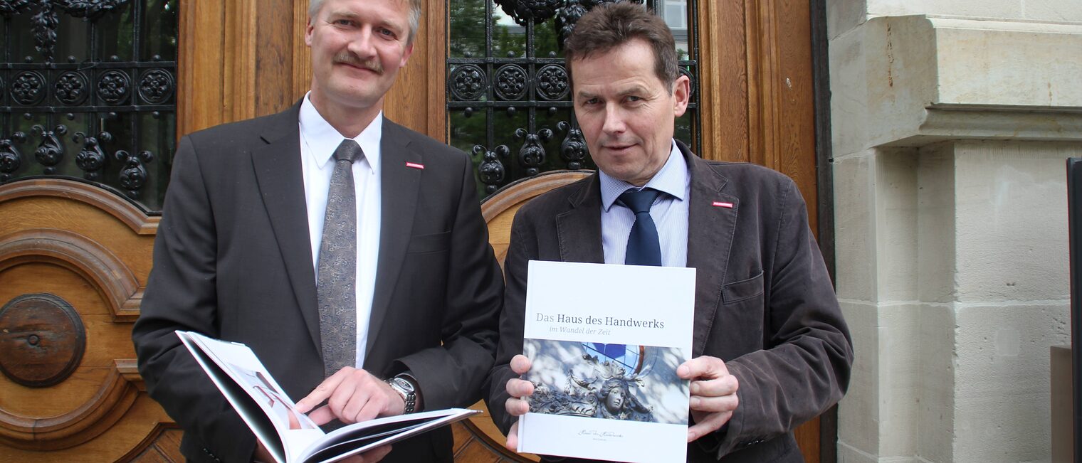 Handwerkskammer-Präsident Hagen Mauer (rechts) und Hauptgeschäftsführer Burghard Grupe präsentieren das Buch "Das Haus des Handwerks im Wandel der Zeit".