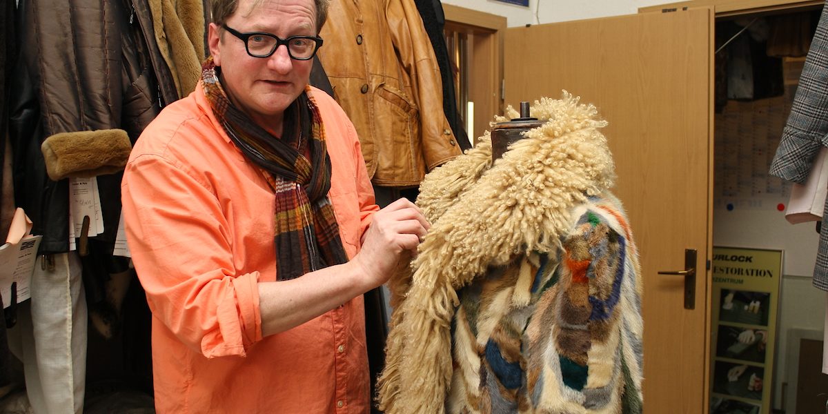 Kürschnermeister Stefan Gehring mit einem Pelzmantel, den er aufgearbeitet hat.