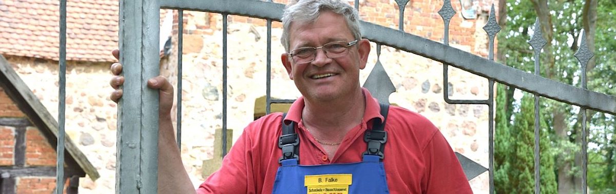 Ist stolz auf "seine" Zaunanlage an der Kirche von Häsewig: Metallbauermeister Bernd Falke.