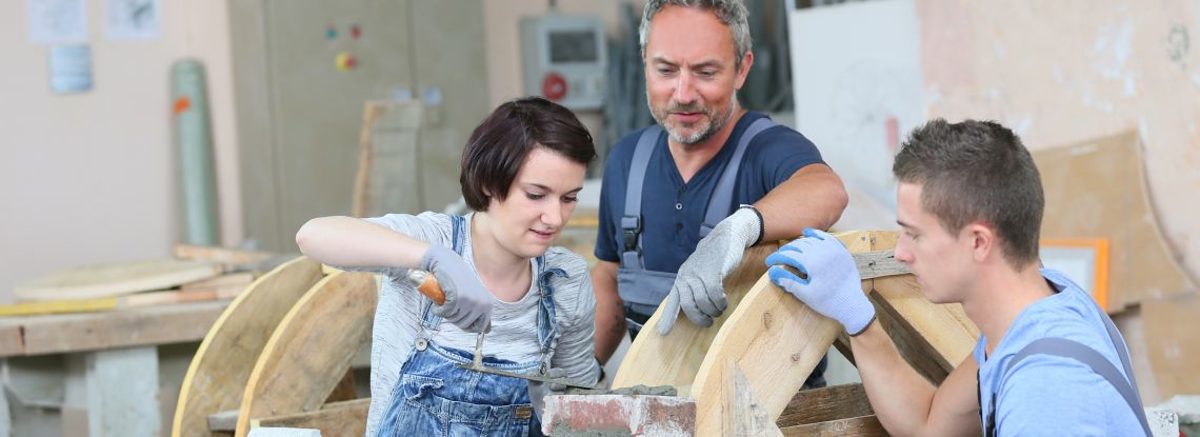Ausbilder zeigt Azubis wie man mauert