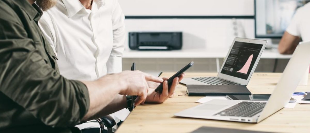 Berater und Kunde sitzen am Lap Top und besprechen Unternehmensbewertung