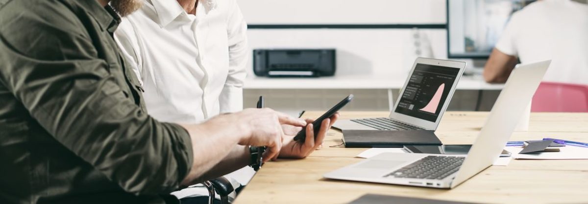 Berater und Kunde sitzen am Lap Top und besprechen Unternehmensbewertung