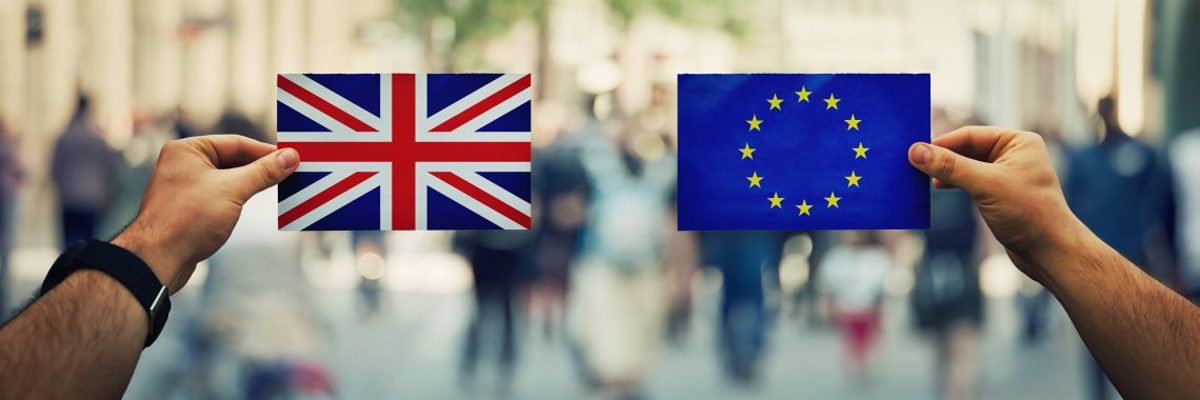 Zwei Hände halten je eine Europa- und eine Großbritannien-Flagge