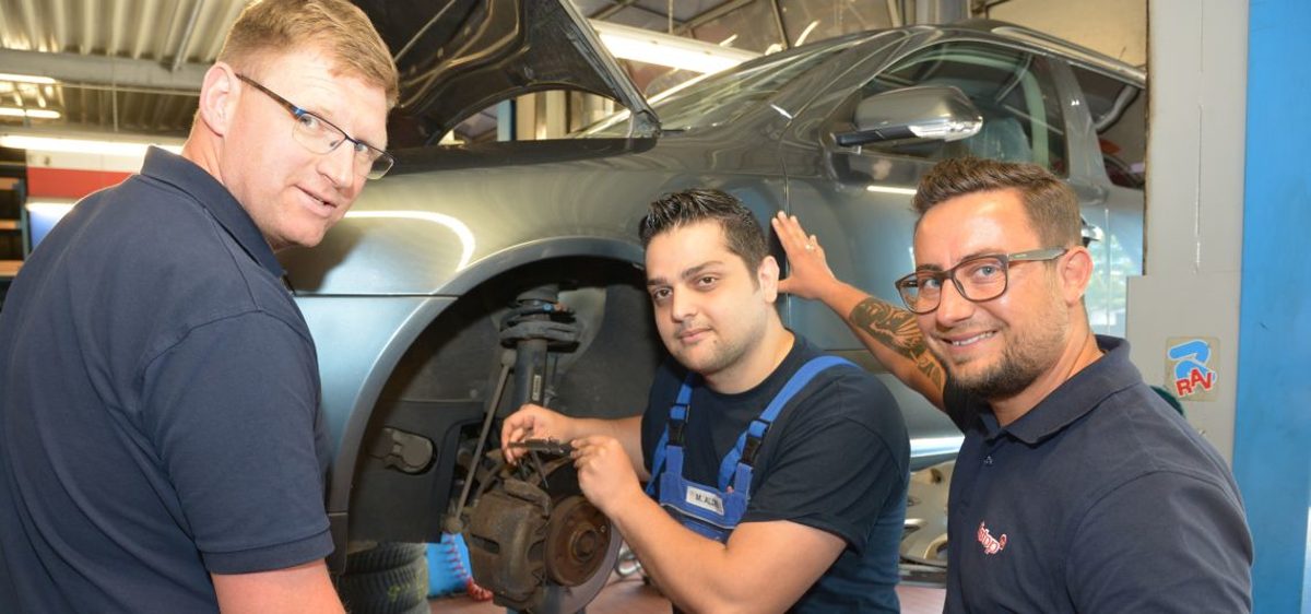 Filialleiter Kay Ostermann (l.) und sein Stellvertreter Dennis Witte (r.) mit ihrem Auszubildenden Mahmoud Aldeek. Azubi Mahmoud und Ausbilder bei Pitstop Magdeburg