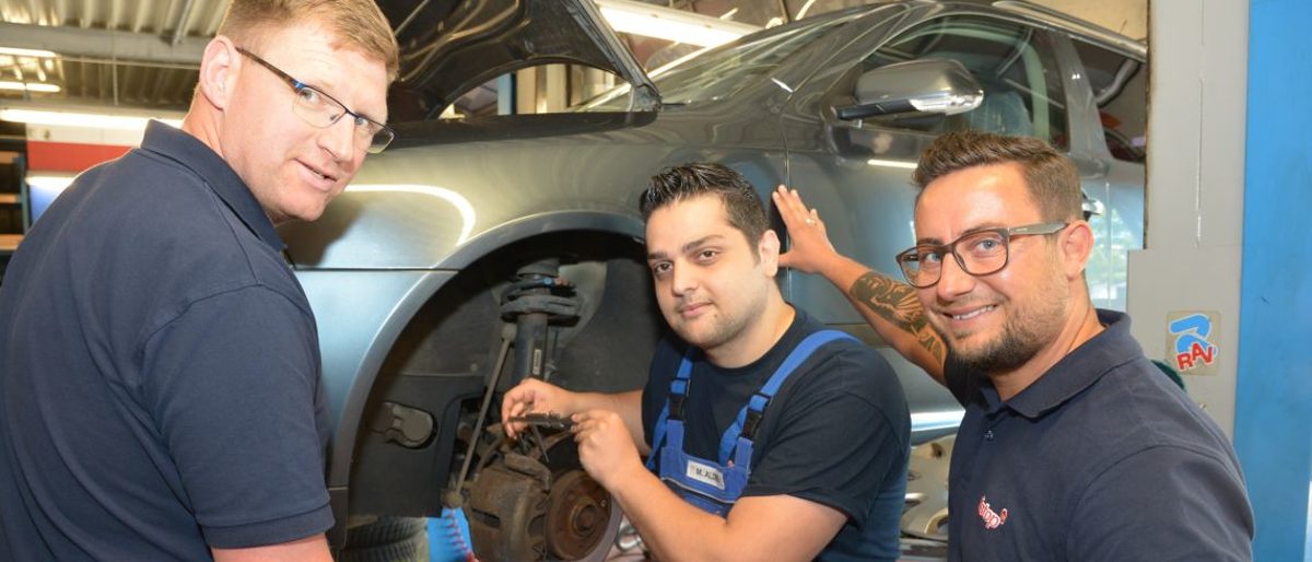 Filialleiter Kay Ostermann (l.) und sein Stellvertreter Dennis Witte (r.) mit ihrem Auszubildenden Mahmoud Aldeek. Azubi Mahmoud und Ausbilder bei Pitstop Magdeburg