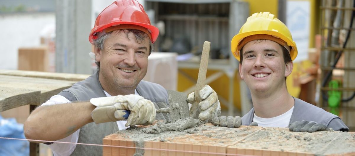 Zwei fröhliche Maurer bei der Arbeit
