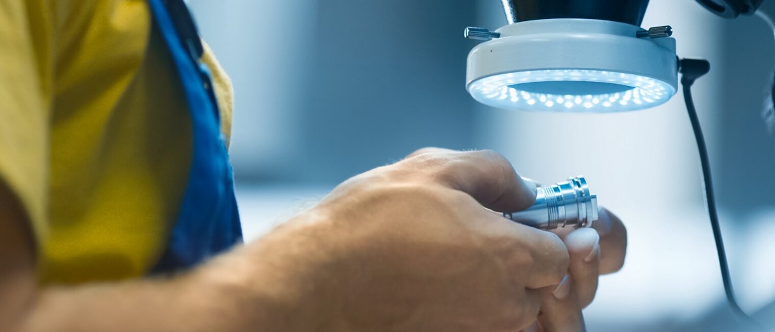 Engineer in a factory is inspecting a metal detail under a microscope with flashlight. Schlagwort(e): accuracy, accurate, caliper, check, checking, closeup, control, coordinate, detail, development, device, equipment, factory, hand, inch, industrial, industry, inspection, inspector, instrument, laborer, light, machine, male, man, manufacture, manufacturing, measurement, metal, metalwork, microscope, parts, person, precise, precision, probe, production, quality, steel, technology, tool, work, worker, workman, workplace, workshop, accuracy, accurate, caliper, check, checking, closeup, control, coordinate, detail, development, device, equipment, factory, hand, inch, industrial, industry, inspection, inspector, instrument, laborer, light, machine, male, man, manufacture, manufacturing, measurement, metal, metalwork, microscope, parts, person, precise, precision, probe, production, quality, steel, technology, tool, work, worker, workman, workplace, workshop