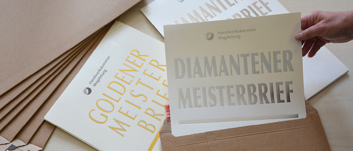 Urkunden werden in Briefumschlag gesteckt.