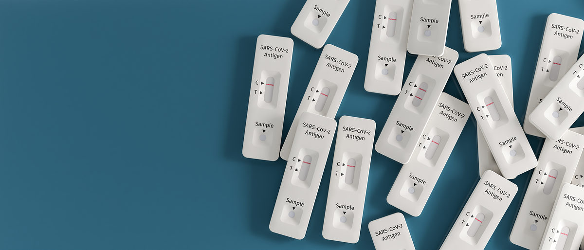 Mass testing for Covid-19 / SARS-CoV-2 infection concept: Several rapid antigen test kits. One kit in the middle showing a positive result (two lines visible) Schlagwort(e): test, antigen, test kit, covid-19, sars-cov-2, coronavirus, self, rapid, quick, sample, result, viral, infection, analysis, positive coronavirus test, screening, infected, contamination, testing, medicine, antibody, detection, diagnosis, laboratory, pandemic, several objects, heap, blue, blue background