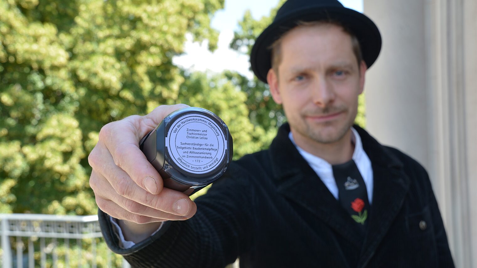 Sachverständiger des Handwerks hält seinen Stempel hoch.