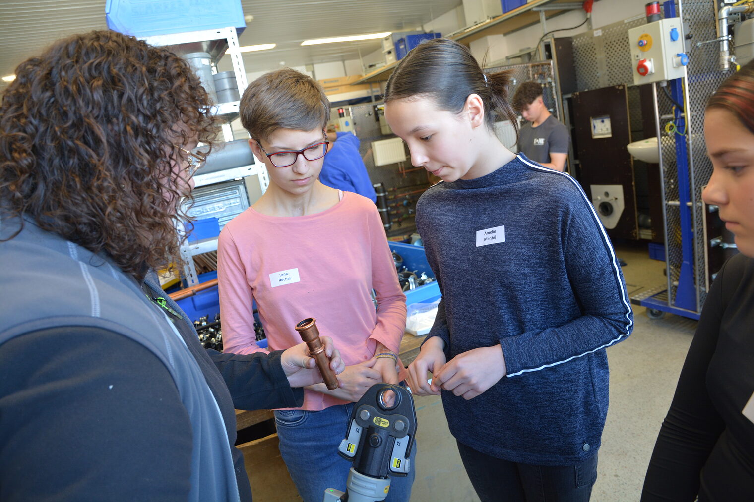 Eine Azubine aus dem Handwerk zeigt Schülerinnen praktische Einblicke in Handwerksberufe.