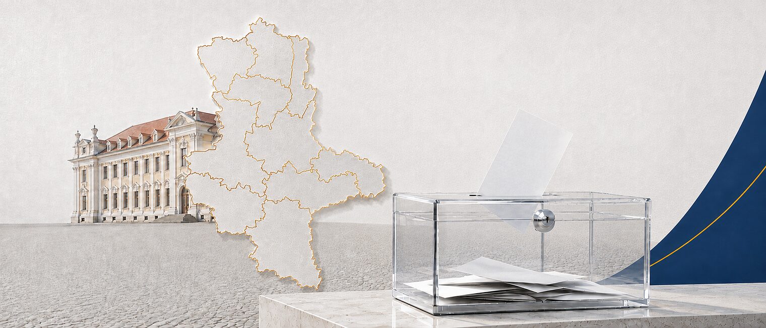 Transparente Wahlurne vor der Silhouette Sachsen-Anhalts und dem Landtagsgebäude am Magdeburger Domplatz. 